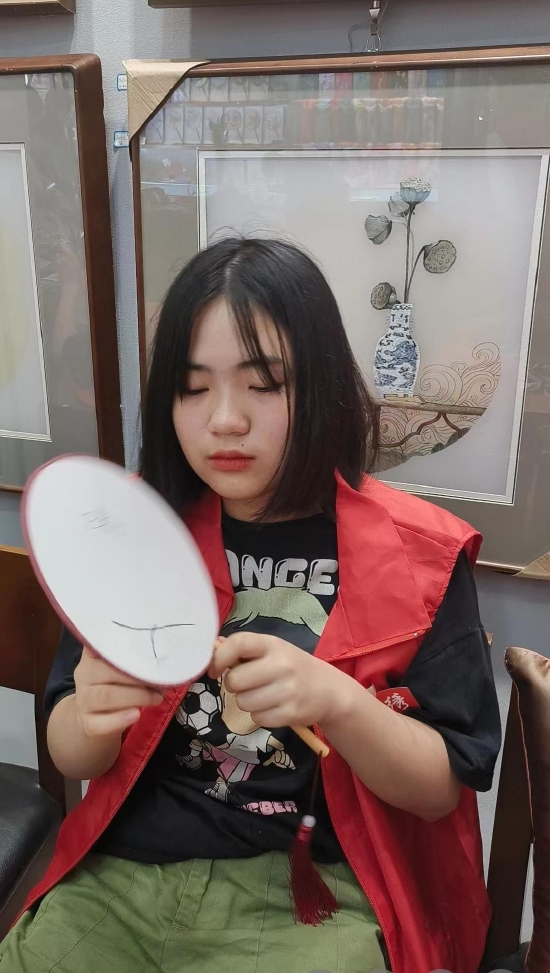 西大附中志愿者黄翊飞扬在学习刺绣的手法