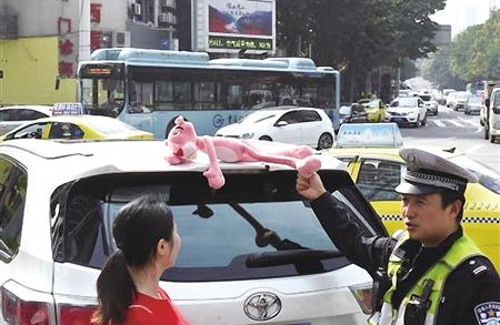民警对车顶玩偶进行整治 市交巡警总队供图