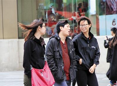 昨日,解放碑,市民在风中行走。本报记者 张锦旗 摄