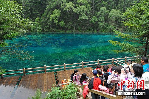 游客兴致勃勃地远拍五彩池。