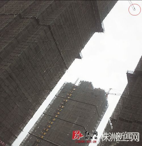 曾某爬上了近百米高的塔吊,从下往上看,人就像一个小点