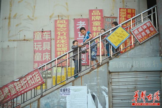 10月7日,一群孩童在往日热闹非凡的长沙下河街批发市场玩耍。范远志 摄