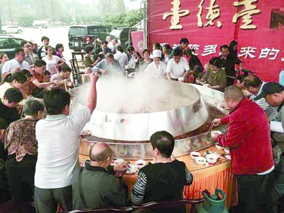 12日,在常德米粉大赛的大众品尝区,许多市民围坐在一口大锅边品尝米粉。 记者 聂诗茼 摄
