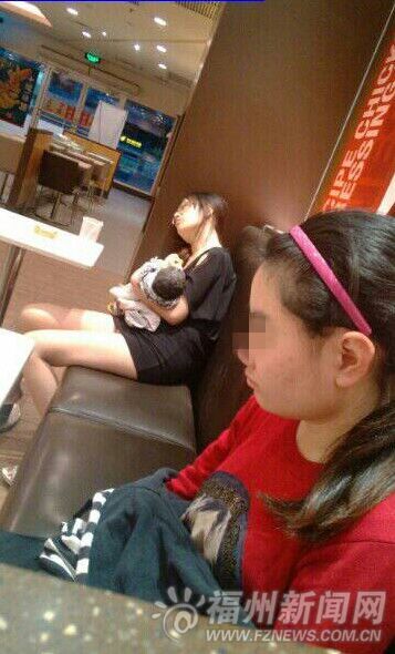 黑衣女子抱着婴儿坐在餐厅里休息。读者陈先生供图