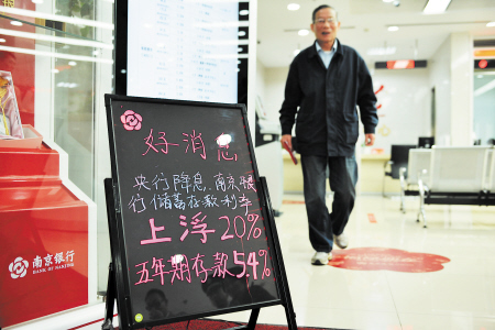 随着人民银行宣布降息并扩大存款利率浮动区间,南京银行、宁波银行等多家中小银行将存款利率一浮到顶。图为南京银行某营业厅设置利率上浮20%的公告牌。 IC 供图