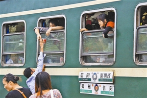 绿皮车进站了,车站售货员通过车窗向旅客递送方便面。