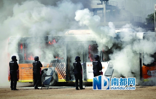 处置公交车纵火:公交车“被纵火”,警员灭火。
