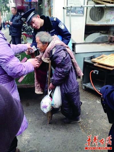 辅警胡鑫被市民拍到照顾乞讨老人,网友看后称他为“最帅民警”。记者 李健 摄