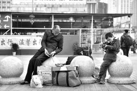 2月11日,株洲火车站,父亲玩玩具车,儿子玩枪,父子俩各有所乐。本报记者金林摄