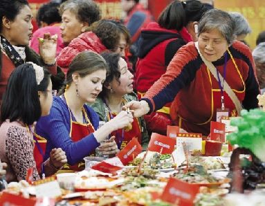 昨日，百亭社区万家宴上，美国女孩凯瑟琳也参与进来，体会中国的年味。本报记者 傅坚 摄