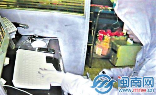 男子打开收银台，快速拿走几叠零钱（监控画面截图）