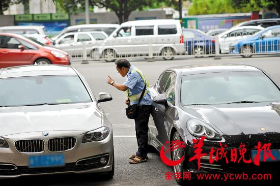 工作人员正在向车主收取停车费 羊城晚报记者 宋金峪 摄