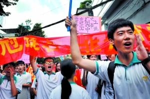 ▲六中考点,学弟学妹们举着牌子给考生们加油。 信息时报记者 郭柯堂 摄
