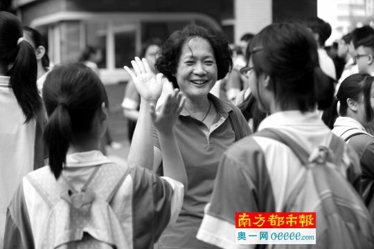 开考前,佛山二中门口,一名荣山中学的老师到二中考场门口与学生击掌加油。