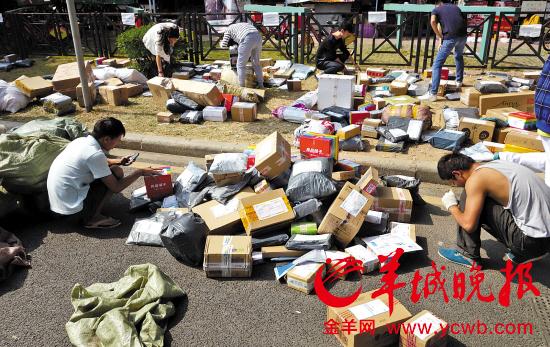 在广州大学城宿舍区前,大大小小的包裹堆满一地 陈秋明摄(资料图片)