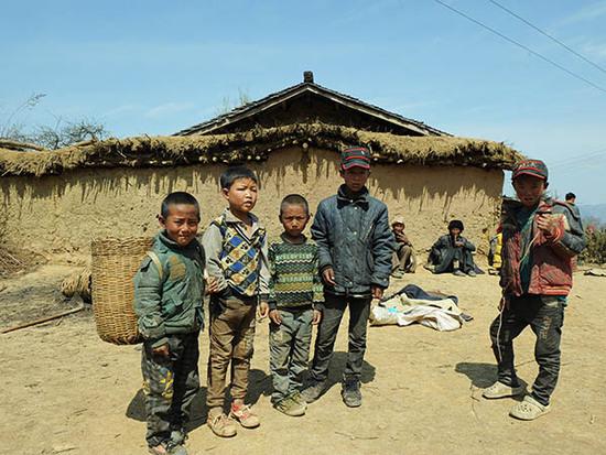四川省大凉山区美姑县拉木阿觉乡马依村的几名孩子站在村里的一处空地上（3月25日摄）。 新华社记者 陈地 摄