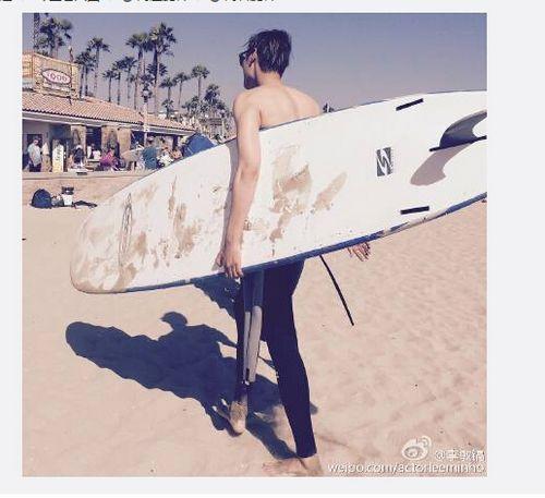 李敏镐晒半裸上身帅照手拿冲浪板走在沙滩上（图）