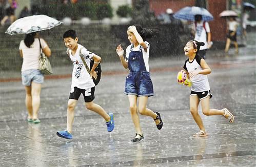 九龙坡区杨家坪步行街,三个小朋友在雨中奔跑.