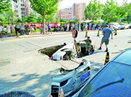 路面塌陷“吞”轿车 路人伸援手救车主
