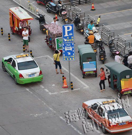 万达广场门口，电动三轮车停路边候客