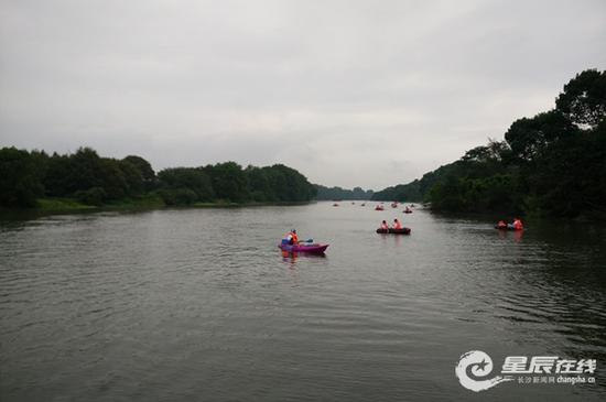 (百余对情侣在浏阳河上冒着寒风暴雨拉开阵势,风雨同舟冲向终点。)