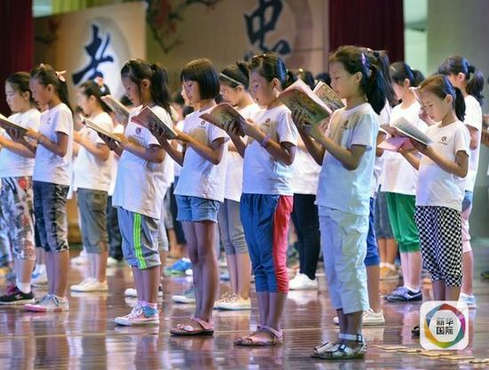 资料：2013年8月6日，中小学生在“孝亲”传统文化夏令营结业典礼上齐声朗诵《弟子规》。（新华社发）
