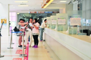 昨日上午,广州市妇儿医疗中心珠江新城院区,昔日大厅里的挂号长龙已经消失,一些家长在研究用手机预约挂号。信息时报记者 康健 摄