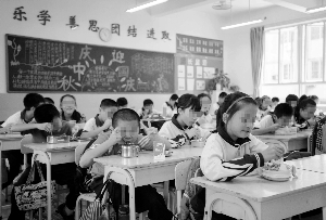 吃完午餐,学生们即将午休。新政实施后因午休人数增多,广州不少学校学生只能趴在课桌上睡觉。