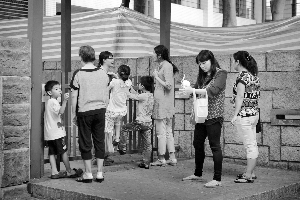 昨日，一些家长带孩子到幼儿园门口与老师进行沟通。从外面可见塑胶操场已经用塑料布围了起来。