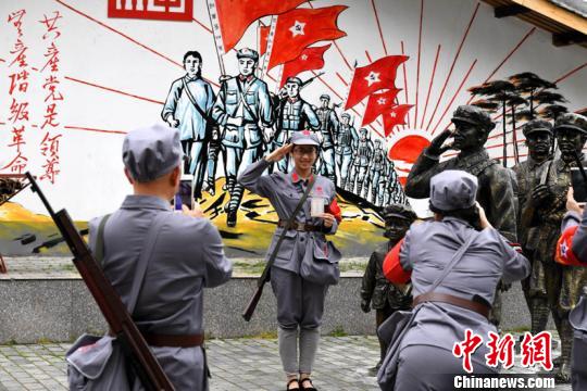 前来接受教育培训的学员与墙画合影。 王东明 摄