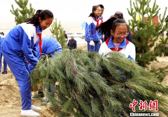 图为学子参与植树。 张添福 摄