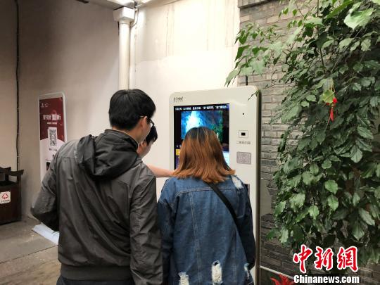 图为在福州三坊七巷景区的游客中心内,几名游客正通过大屏“点读机”,了解三坊七巷的概况。 闫旭 摄