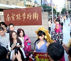 女子在闹市扮豪乳摇钱树