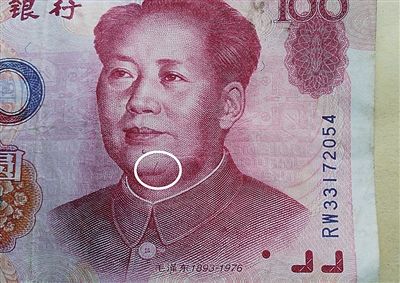 99年版百元大钞头像右边痣下方,有一条3毫米的红色竖曲线(白圈处)。