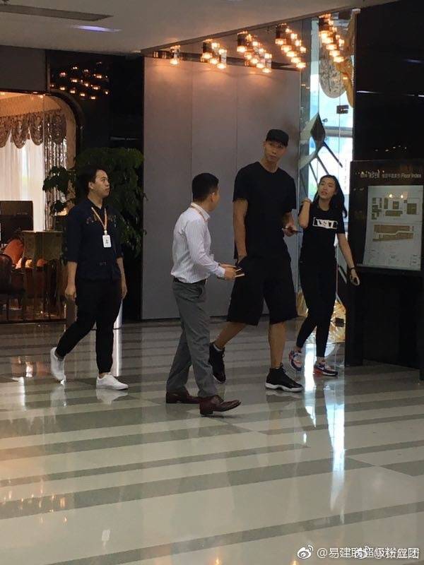 在另一张照片中，荆灵身穿自家品牌的设计感外套，利落的剪裁衬托出她作为前模特的优越身段，即使是宽松的街头风格，也难掩其优雅气质，而易建联则像一位尽职的守护者，紧随妻子身旁。