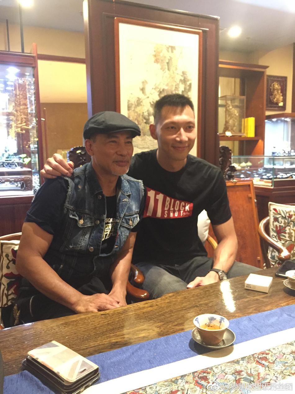 餐桌前，任达华亲切地将手搭在阿联肩上，如同一位和蔼的大哥，阿联则露出腼腆而尊敬的笑容，气氛温馨融洽。