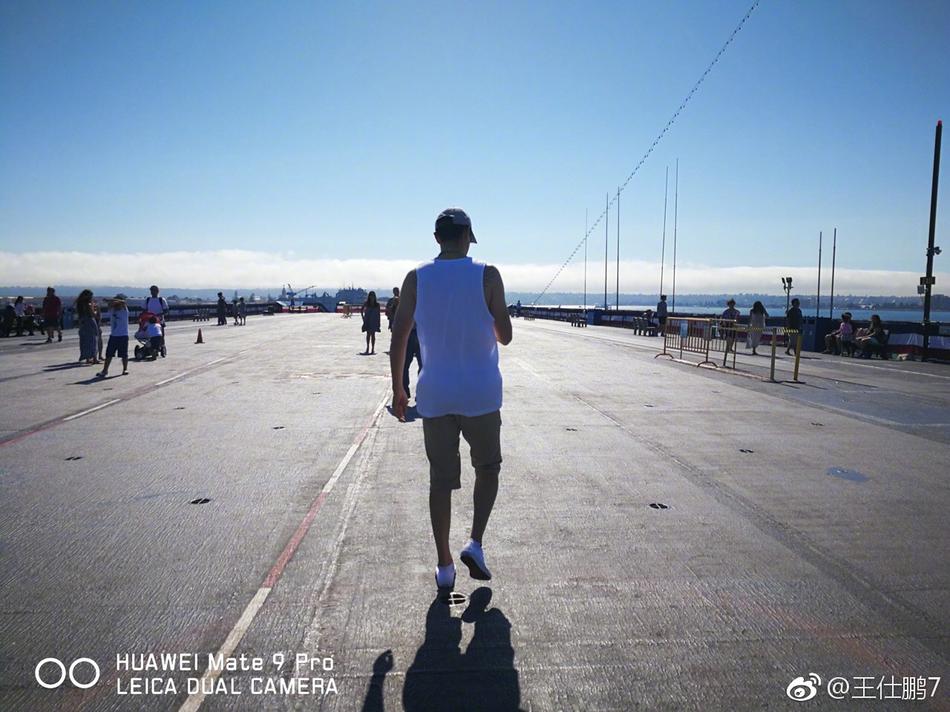 巴尔博亚公园的标志性钟楼在午后的阳光下显得庄重而优雅,王仕鹏站在西班牙殖民复兴风格的拱门走廊下,抬头仰望精美的建筑细节。