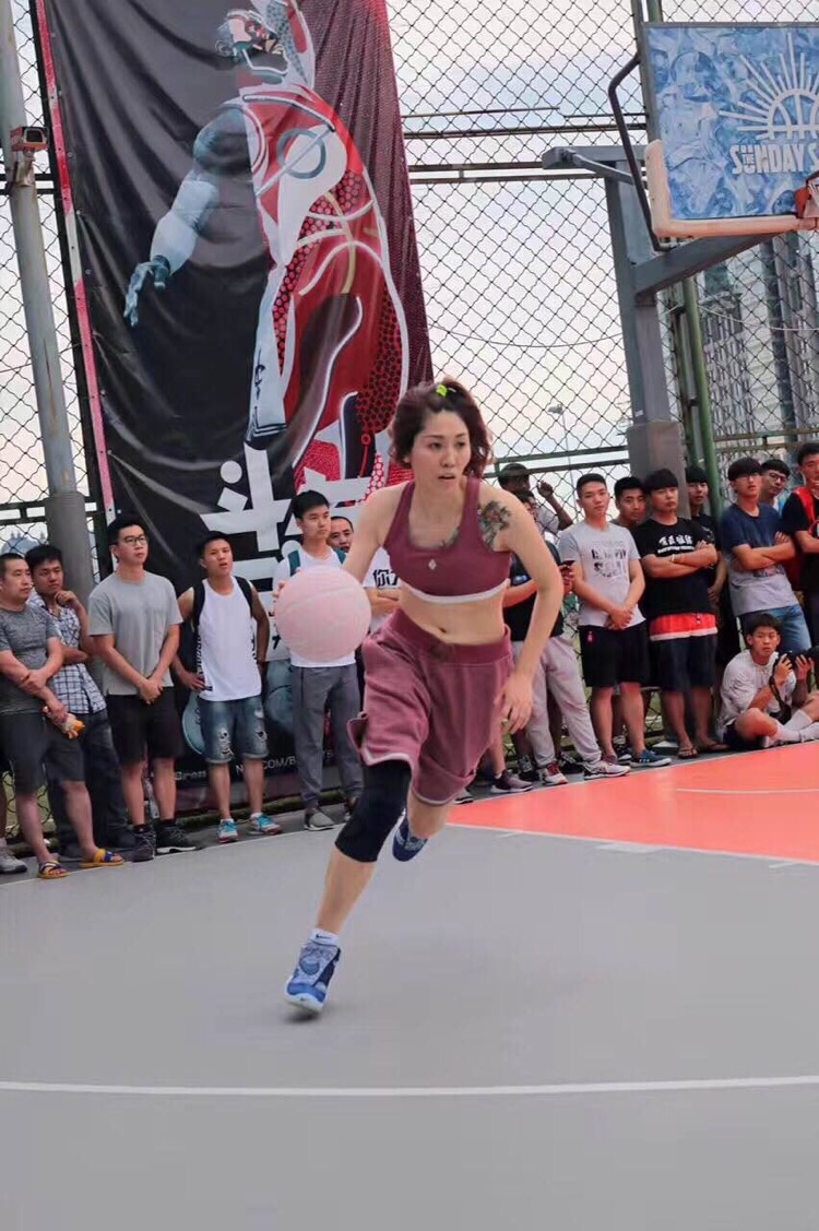 特写镜头下，一位女神队队员的球衣在阳光下泛着细腻的光泽，Pigalle联名款特有的剪裁勾勒出她矫健的身姿，专注运球的侧脸显得格外动人。