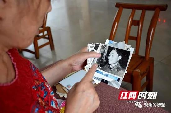 (妻子吴春英翻看着“老姜”在部队时,写给家里的一封封书信。)