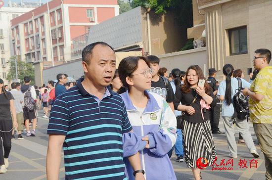 7日，高考第一天考试结束后，考生挽着父亲的手离开考场 王子文/摄