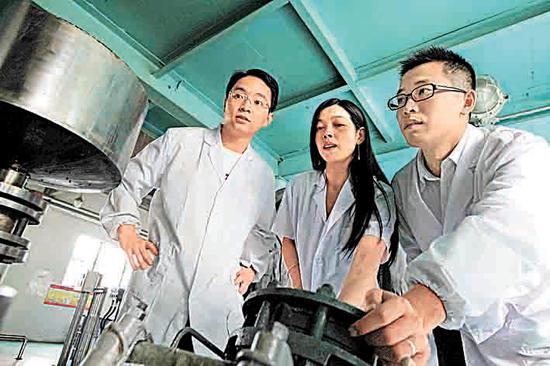 传化集团党员攻关小组在车间查看产品质量。