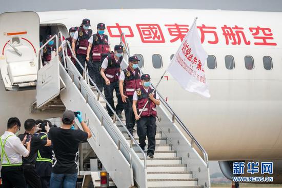 2020年3月29日,在老挝首都万象瓦岱国际机场,中国抗疫医疗专家组成员走下飞机。中国抗疫医疗专家组29日抵达老挝首都万象。专家组同时随机携带了医疗救治、防护物资及中西药品等中方捐赠的医疗物资。专家组一行12人,由云南省感染防控、重症监护、流行病、实验室检测等多个领域医护专家组成。新华社发(凯乔摄)