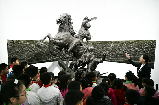 2019年4月4日,在东北烈士纪念馆,学生们在听讲解员讲解。