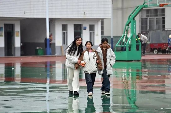 在桂林市全州县蕉江瑶族乡中心小学,21岁的凤艳萍(左一)和妹妹盘云芳(右一)、堂妹盘宇婷走在校园里(2月28日摄)。