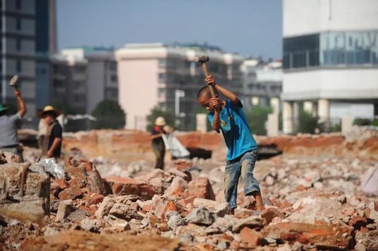 在柳州市北雀路一处工地,熊三耶和伙伴们在打铁(2013年8月29日摄)。