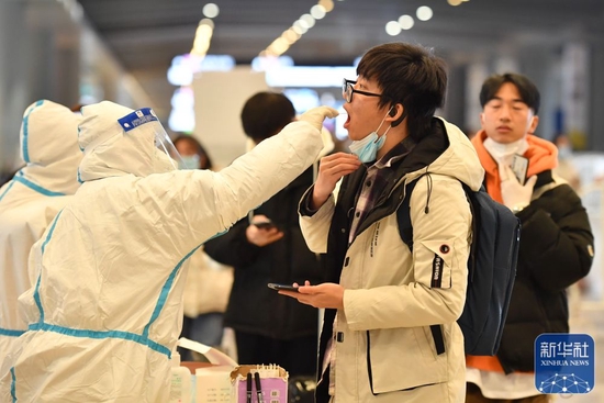 1月14日，乘坐专列返回西安的学生在西安北站出站口核酸检测点接受检测。