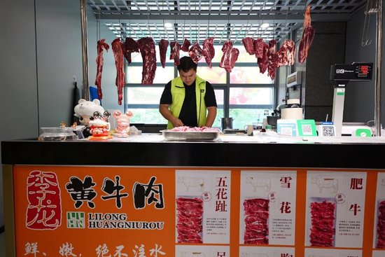 龙泰吉在切肉。新华社记者 王丰 摄