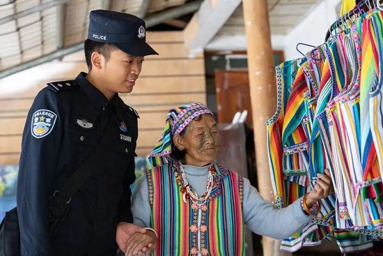  民警余润强跟文面女奶奶学习独龙族编制