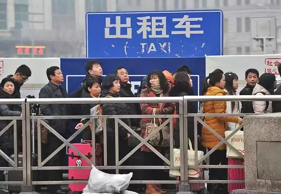 火车站、机场外的出租车候车处,往往大排长龙。图/新华社