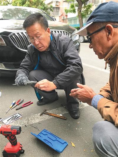 夏洪江(左)和队员正在为小区维修邮箱。受访者供图